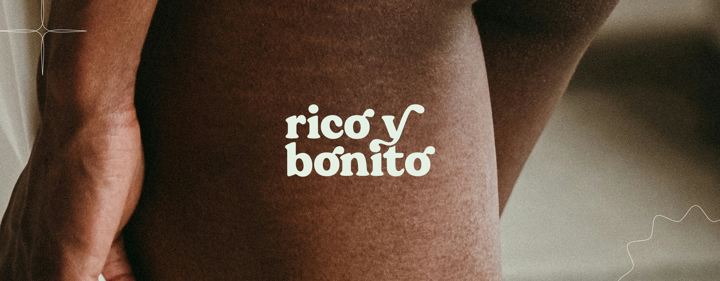 Rico y Bonito visual identity in white over a photograph of a Black person's thighs, showing stretch marks, wrinkles and skin pores.