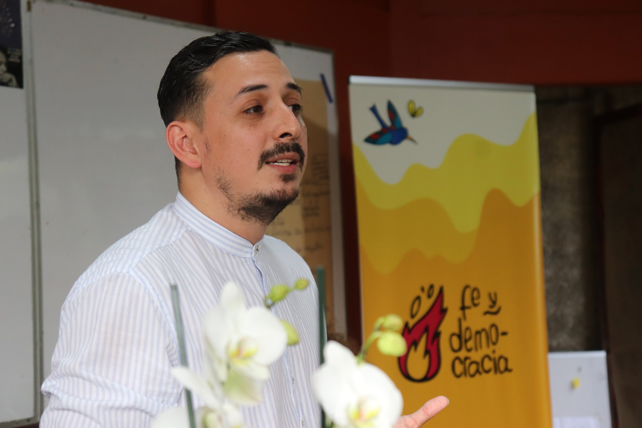 Photography of “Politics and Masculinities” workshop led by Ariel Robles in Costa Rica, with a banner with Fe y Democracia’s branding in the back